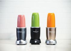 three different colored blenders sitting next to each other