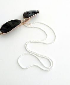 Beaded sunglasses chain, Eyewear holder, Sunglasses necklace, White beaded glasses holder, Sunglasses white strap, Eyeglasses beaded cord Beautiful fashion trend sunglasses beaded string This sunglass strap is lightweight, comfortable to wear and secures your sunglasses on your neck. Fashion trend accessory for the summer!  Total length is 70cm / 27.7 inches. Beautifully packaged and ready for gift giving.  JEWELRY CARE: Please take care of your jewelry do not wear in the shower, swimming pool, White Glasses Chains As Summer Gift, White Glasses Chains For Summer Gift, Adjustable White Glasses Chains With Round Beads, White Beaded Glasses Chain As A Gift, White Adjustable Glasses Chains For Summer, Handmade White Glasses Chains With Round Beads, Handmade White Glasses Chains For Summer, White Adjustable Glasses Chains For Fashion, Handmade White Glasses Chains