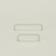 two white handles on a white surface with no one in the photo looking at them