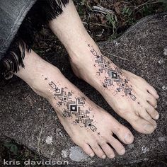 two feet with black and white tattoos on them