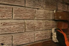 a close up of a brick wall with an orange strap hanging from it's side