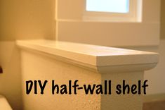 a white toilet sitting in a bathroom next to a window with the words diy half - wall shelf above it