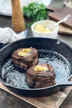 two steaks are cooking in a skillet