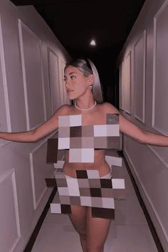 a woman is walking down the hallway in a dress made out of paper cubes