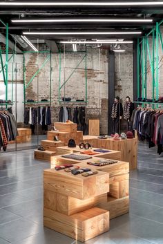 the inside of a clothing store with lots of wooden tables and benches in front of it