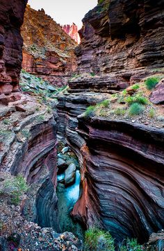 a narrow river cuts through the side of a canyon in an area that looks like it is