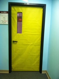 a yellow door is in the corner of a room with a blue wall and carpet