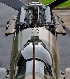 the engine of an airplane is visible from above on the tarmac with grass in the background