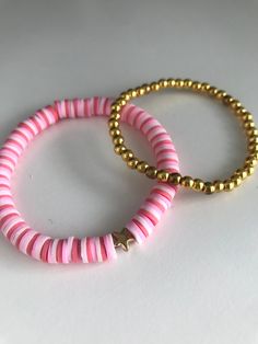 This bracelet set is called the Pink Wonders Bracelet Set. It is made with clay beads and tiny gold balls. The colors are pink and gold. These bracelets are around 6.5-7 inches. If you want a bigger or smaller size message me. Pink Bracelet With Gold Beads As Gift, Pink Friendship Bracelets With Spacer Beads, Pink Stackable Heishi Beads Bracelets, Pink Heishi Beads Bracelet With Gold Beads, Pink Heishi Beads Stretch Bracelet Stackable, Pink Stackable Heishi Beads Stretch Bracelet, Adjustable Pink Beaded Bracelets With Gold Beads, Pink Heishi Beads Bracelets For Friendship, Pink Stackable Beaded Bracelets With Round Beads