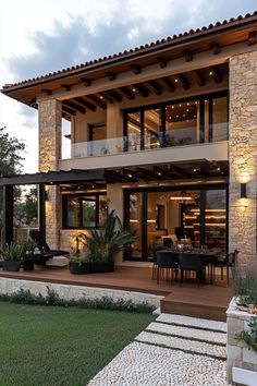 a modern house with an outdoor dining area and stone steps leading up to the front door