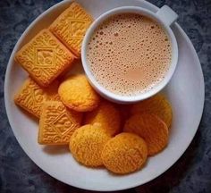 there is a white plate with cookies on it and a cup of coffee in the middle