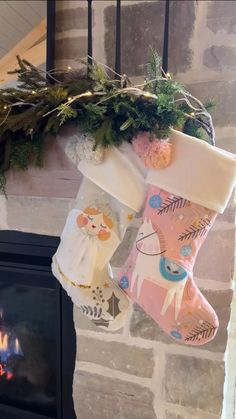 two stockings hanging from a fireplace in front of a fire place