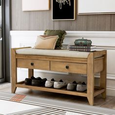 a wooden bench with shoes on it in front of a painting and framed pictures above