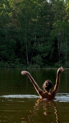 a woman is swimming in the water with her arms outstretched