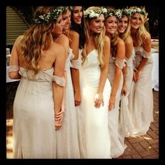 a group of women in white dresses standing next to each other