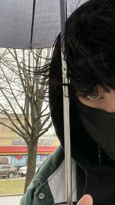 a person wearing a face mask holding an umbrella