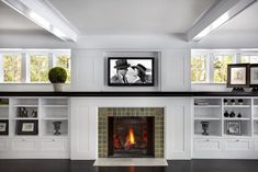 a living room filled with furniture and a fire place in front of a tv mounted on the wall