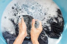 someone is washing their hands in a blue bowl with soap and water on the floor