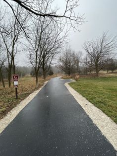 a paved road with trees and grass on both sides