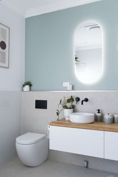 a bathroom with a sink, toilet and mirror in the corner next to each other