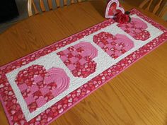 a table runner with the word love spelled out in red and pink hearts on it