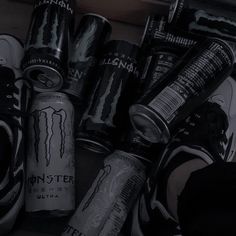 several monster energy drinks are stacked on top of each other in a bin with the lids open