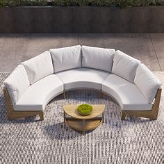 a large white couch sitting on top of a rug next to a wooden coffee table