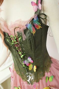 a woman wearing a green corset with butterflies on it