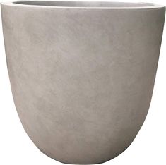 a large gray planter sitting on top of a white table next to a wall