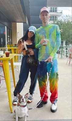 a man and woman standing next to each other with a dog in front of them