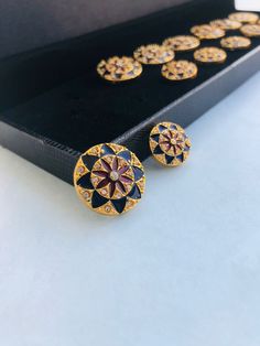 two pairs of earrings sitting on top of a black box