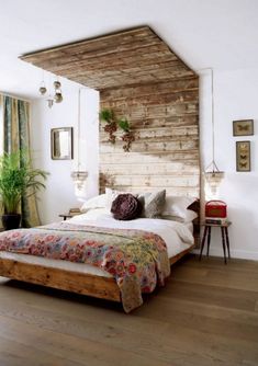 a bed sitting in a bedroom next to a wooden headboard and window sill