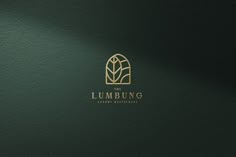 the lumbung logo is shown on a green wall with gold trimmings