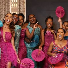 a group of women standing next to each other holding pink parasols in their hands