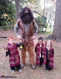 a man with long hair and beard standing next to four children in maroon robes, all dressed up