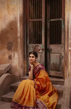 a woman sitting on steps in front of a door