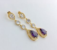 I've created these absolutely gorgeous super sparkly long purple amethyst crystal earrings in gold plated brass setting. Earrings feature a large teardrop with pear cut purple amethyst cubic zirconia center surrounded by tiny round zirconia crystals. Teardrop dangles from a bright cubic zirconia ear stud and two round cubic zirconia connectors. Total length of the earrings is 6 cms. For matching necklace click: For matching bracelet click: To browse my collection click : https://www.etsy.com/sho Amethyst Purple Earrings For Wedding, Purple Amethyst Earrings For Wedding, Lavender Amethyst Earrings For Wedding, Purple Bridesmaid, Purple Bridesmaids, Gold Bridal Earrings, Amethyst Gold, Earrings Purple, Ear Stud