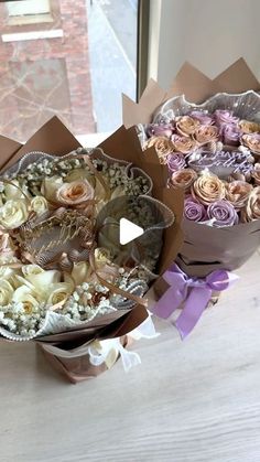 two large bouquets of flowers sitting on top of a table next to each other