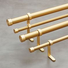 three gold colored metal racks on a gray surface