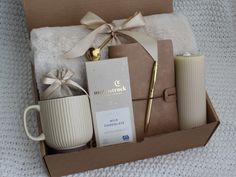 an open box containing coffee, mugs and other items on a white carpeted surface