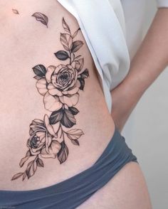 a woman's stomach with flowers and leaves on it