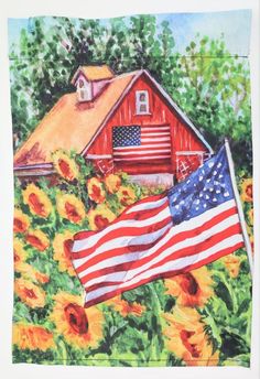 an american flag and sunflowers in front of a red barn