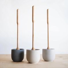 three white and black vases with wooden sticks sticking out of them