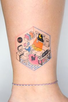 a woman's foot with a small tattoo on the side of her leg that has an image of a living room and kitchen