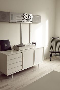 a record player sitting on top of a white cabinet