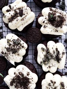 oreo cookies with white frosting and chocolate chips on a cooling rack for display