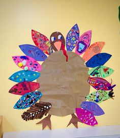 a turkey made out of paper on top of a table next to a yellow wall