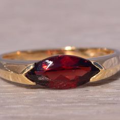 This Stunning Piece, Known As The Crimson Marquise Ring, Features A Captivating Marquise-Cut Garnet At Its Center Set East To West. The Rich, Deep Red Garnet Is Elegantly Set In A 14 Karat Yellow Gold Band, Designed With Sleek, Modern Lines That Add A Touch Of Sophistication. The Ring Is Currently A Finger Size 7 But Can Be Adjusted To Any Finger Size For An Additional Charge Upon Request, Ensuring A Perfect Fit. Elegant Faceted Ruby Ring In Yellow Gold, Elegant Yellow Gold Faceted Ruby Ring, Marquise Ring, Garnet Ring, Garnet Rings, Marquise Cut, Red Garnet, Gold Band, Womens Jewelry Rings