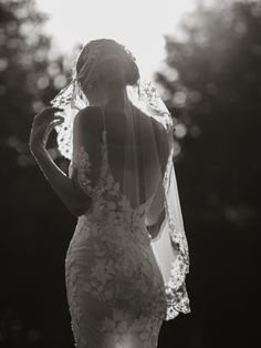 the back of a bride's wedding dress, with her veil blowing in the wind