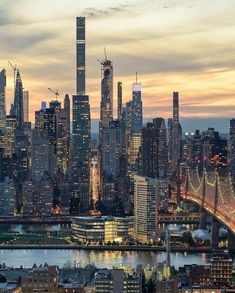 the city skyline is lit up at night, with skyscrapers in the foreground